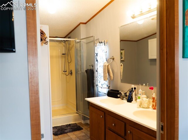 920 E 14th St, La Junta, CO 81050 - bathroom with vanity, crown molding, a textured ceiling, and walk in shower