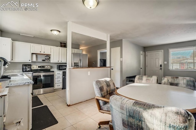 kitchen featuring white cabinetry, sink, light tile patterned flooring, and stainless steel appliances