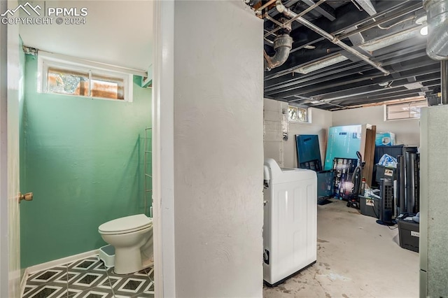 interior space featuring washer / dryer, concrete floors, and toilet