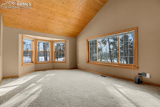 carpeted empty room featuring wood ceiling and high vaulted ceiling