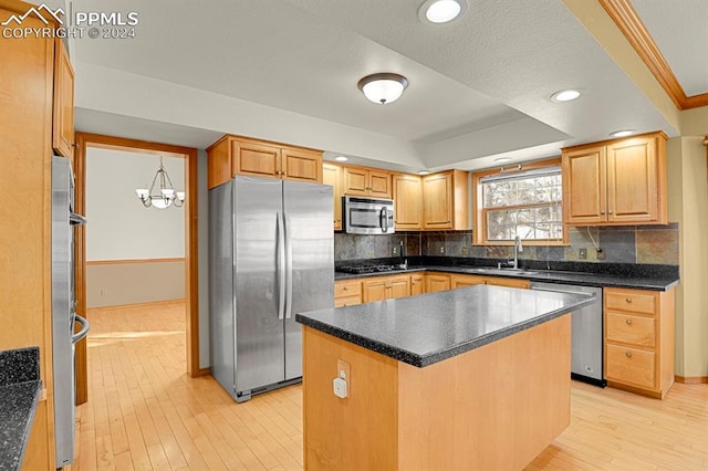 kitchen featuring a center island, sink, stainless steel appliances, light hardwood / wood-style floors, and a chandelier