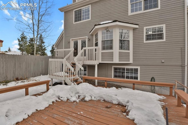 snow covered rear of property featuring a wooden deck