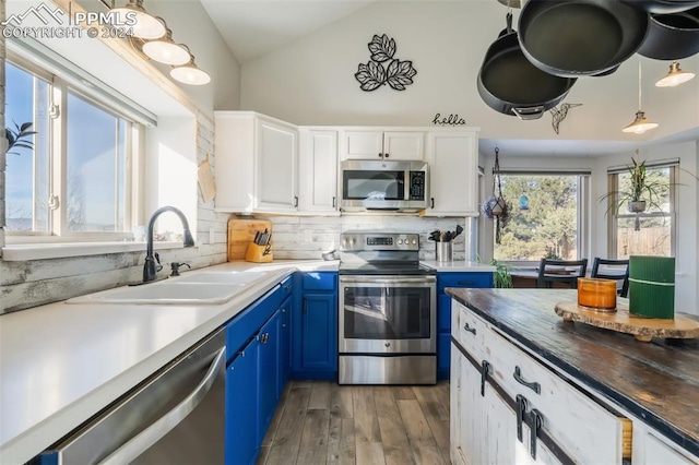 kitchen featuring blue cabinetry, white cabinetry, sink, stainless steel appliances, and dark hardwood / wood-style floors