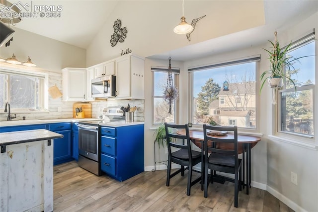 kitchen featuring blue cabinetry, white cabinetry, light hardwood / wood-style flooring, and appliances with stainless steel finishes