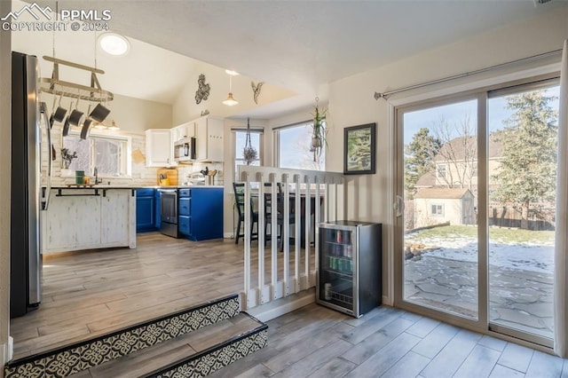 kitchen featuring light wood-type flooring, white cabinetry, blue cabinets, and a wealth of natural light