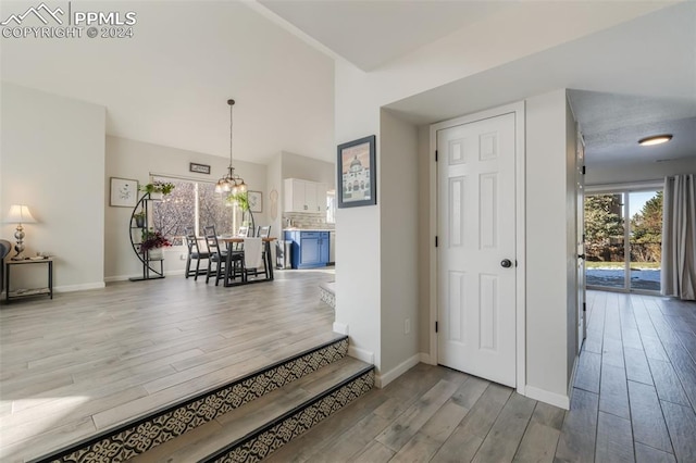 hall with a notable chandelier and light hardwood / wood-style floors