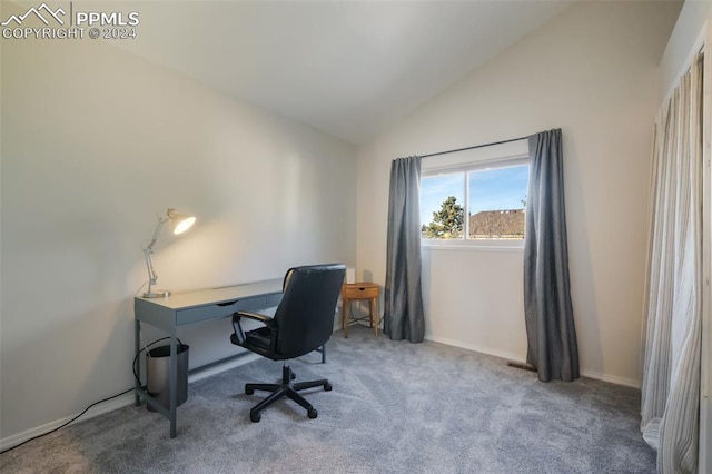 carpeted home office featuring lofted ceiling