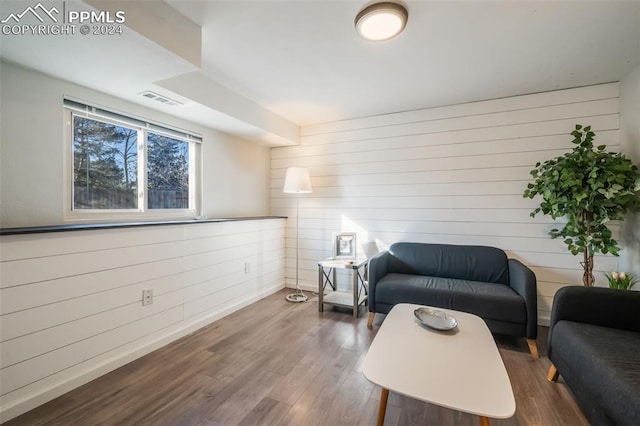 interior space with wood walls and hardwood / wood-style flooring