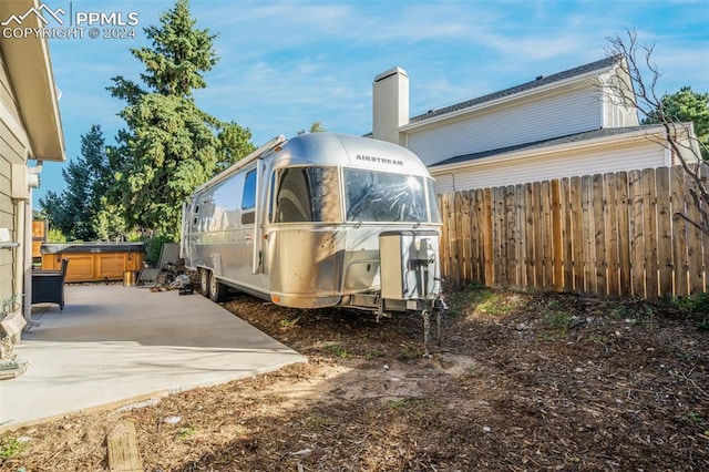 back of property featuring a patio and a hot tub