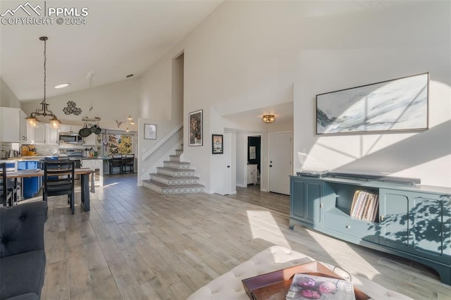 living room featuring light hardwood / wood-style floors and high vaulted ceiling