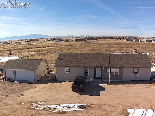 view of front facade featuring a mountain view, a garage, and an outdoor structure