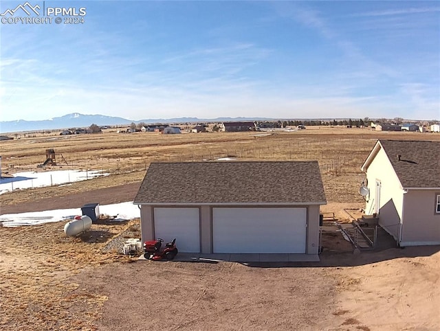 exterior space featuring a mountain view, a rural view, and a garage