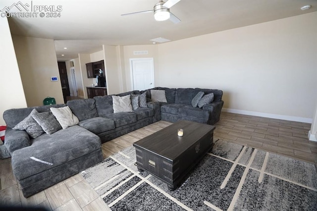 living room with wood-type flooring and ceiling fan