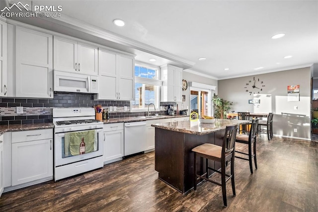 kitchen with dark hardwood / wood-style floors, dark stone countertops, crown molding, white appliances, and white cabinets