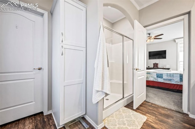 bathroom with hardwood / wood-style floors, ceiling fan, ornamental molding, and walk in shower