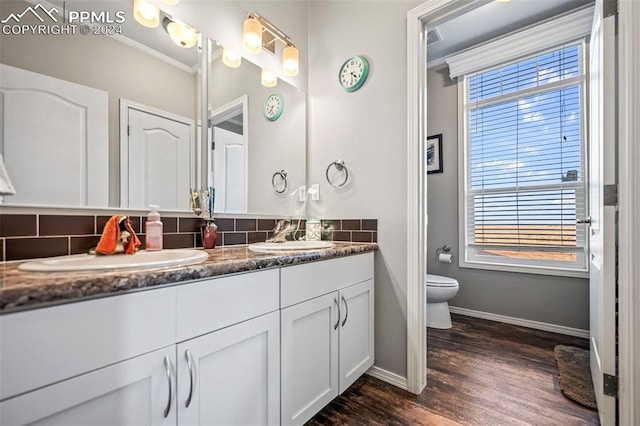 bathroom featuring vanity, backsplash, hardwood / wood-style flooring, and toilet