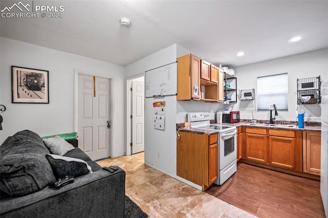 kitchen featuring white range with electric stovetop, sink, and light hardwood / wood-style flooring