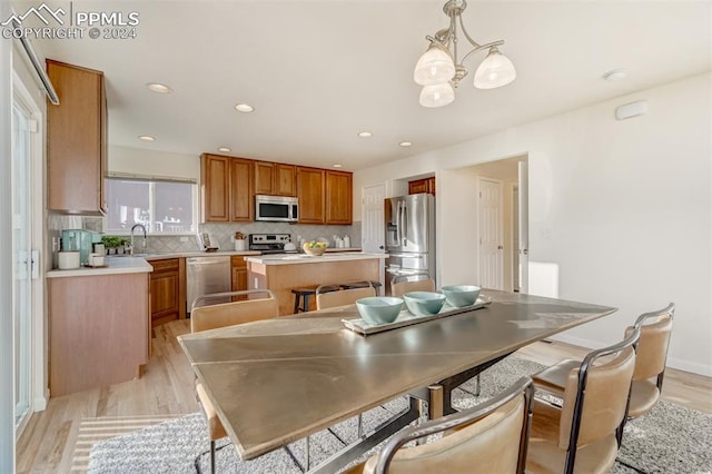 dining space with a chandelier, light hardwood / wood-style flooring, and sink