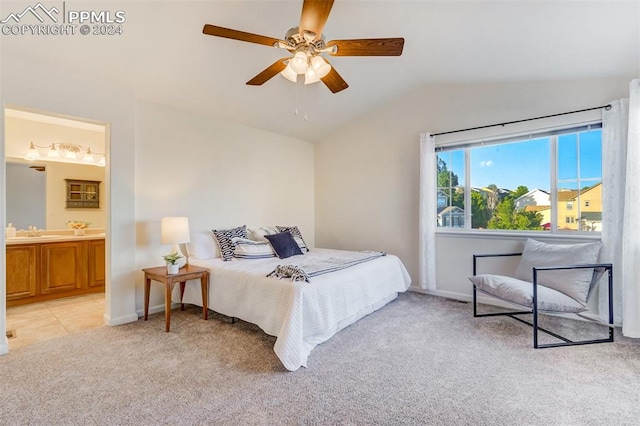 carpeted bedroom with ensuite bathroom, ceiling fan, sink, and vaulted ceiling