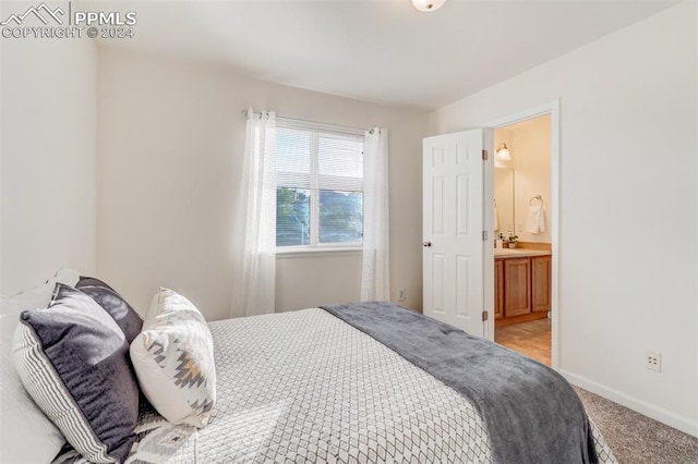 carpeted bedroom featuring ensuite bath