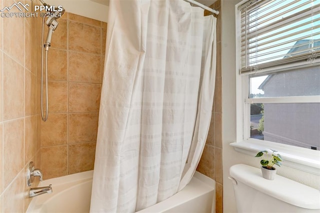 bathroom with plenty of natural light, shower / bath combination with curtain, and toilet