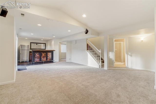 unfurnished living room with light carpet and lofted ceiling