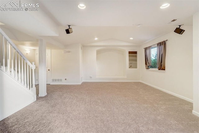 empty room with carpet flooring and lofted ceiling