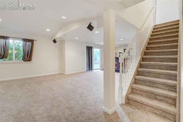 staircase featuring carpet flooring and lofted ceiling