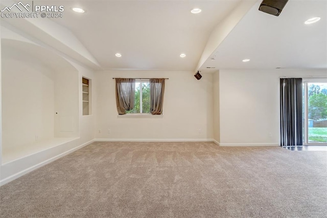 spare room with light carpet and lofted ceiling