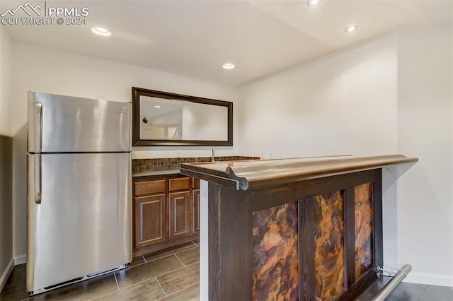 bar featuring stainless steel refrigerator