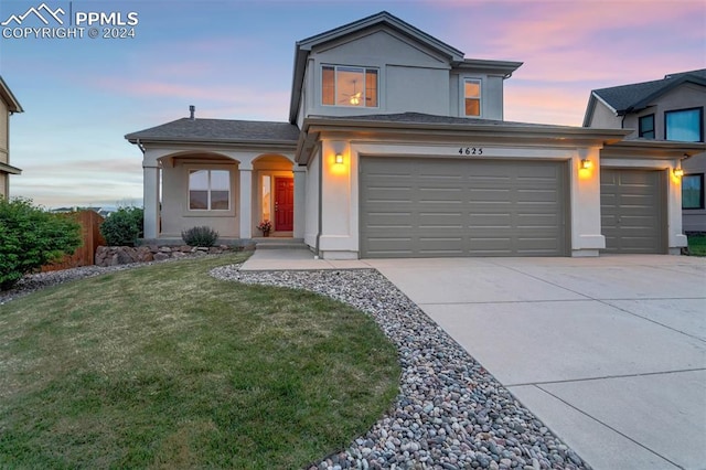 view of property with a garage and a yard