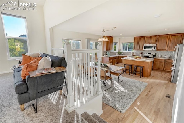 living room with light hardwood / wood-style floors, an inviting chandelier, and a healthy amount of sunlight