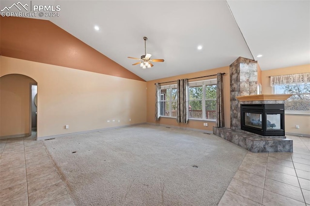 unfurnished living room featuring a multi sided fireplace, ceiling fan, light tile patterned floors, and a healthy amount of sunlight