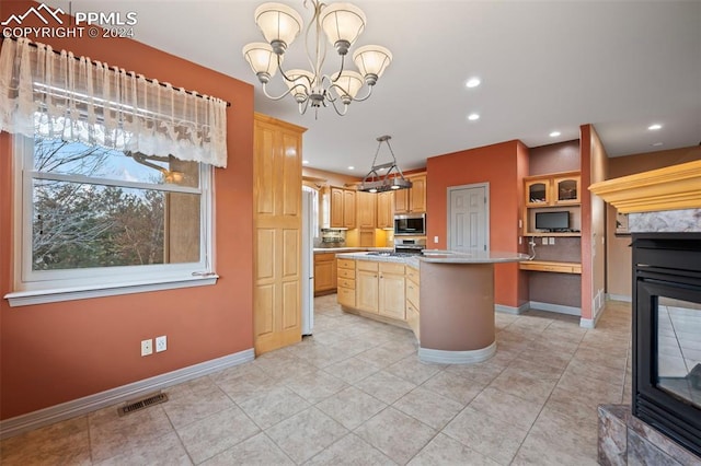 kitchen featuring a center island, stainless steel microwave, light brown cabinets, a multi sided fireplace, and a notable chandelier