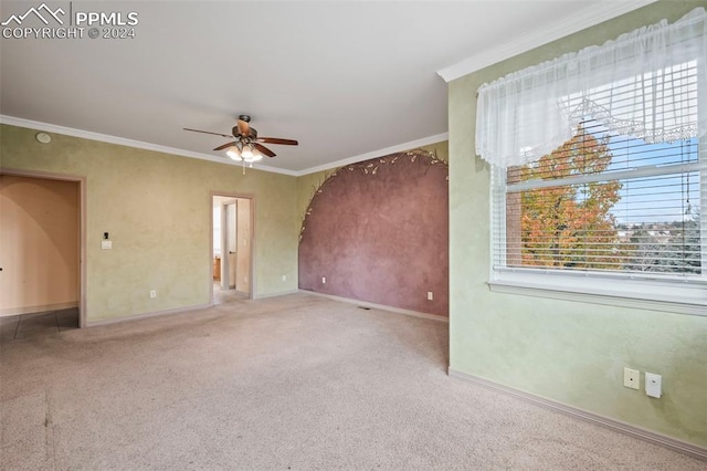 carpeted empty room featuring ceiling fan and crown molding