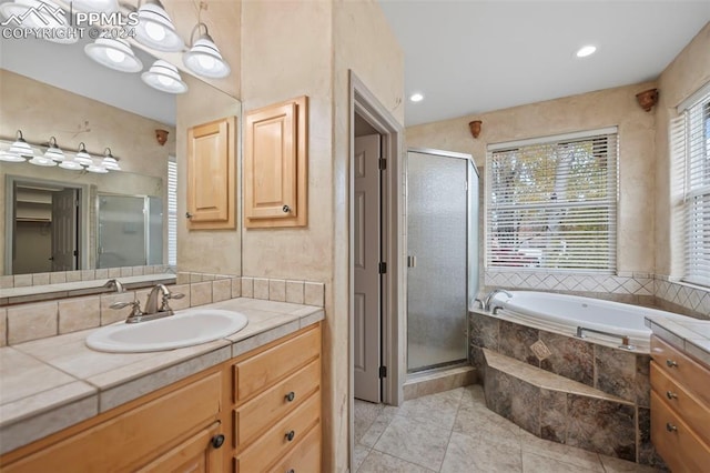 bathroom featuring tile patterned flooring, vanity, and shower with separate bathtub