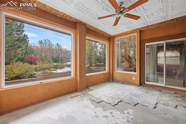 unfurnished sunroom featuring a wealth of natural light and ceiling fan