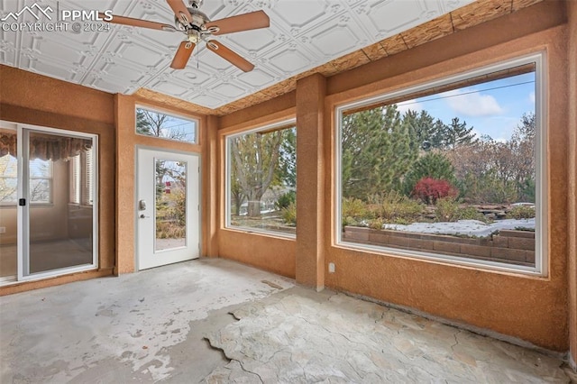 unfurnished sunroom with plenty of natural light and ceiling fan