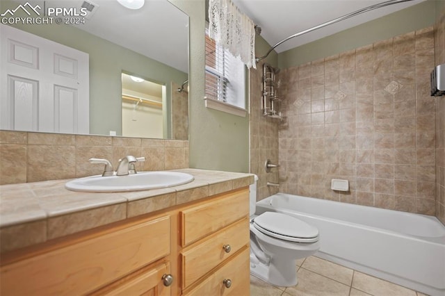 full bathroom with tiled shower / bath combo, tasteful backsplash, tile patterned floors, toilet, and vanity