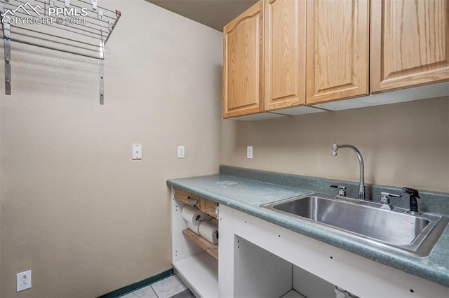 kitchen with light tile patterned floors, sink, and light brown cabinetry