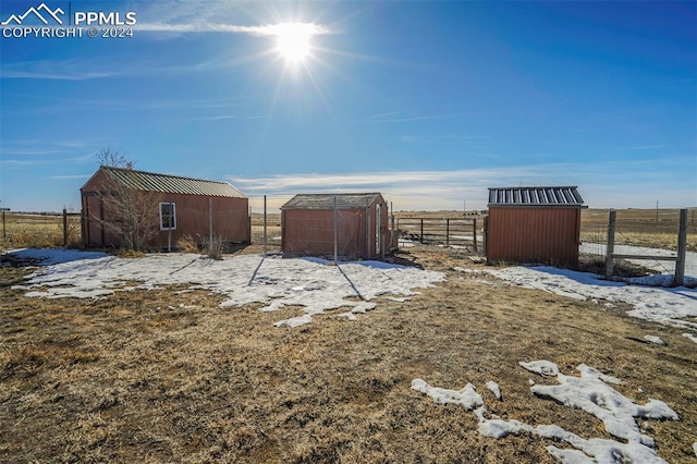 view of yard with a rural view and an outdoor structure