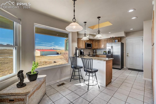 kitchen featuring kitchen peninsula, stainless steel appliances, and a healthy amount of sunlight