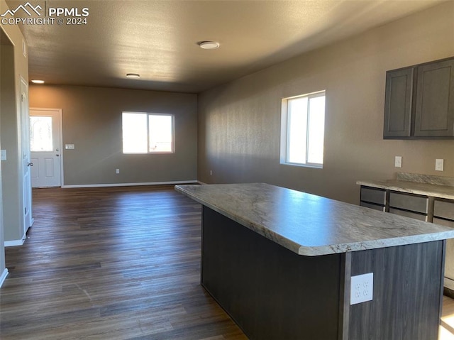 kitchen featuring plenty of natural light, a kitchen island, and dark hardwood / wood-style flooring