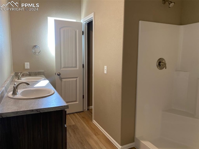 bathroom featuring wood-type flooring, vanity, and walk in shower