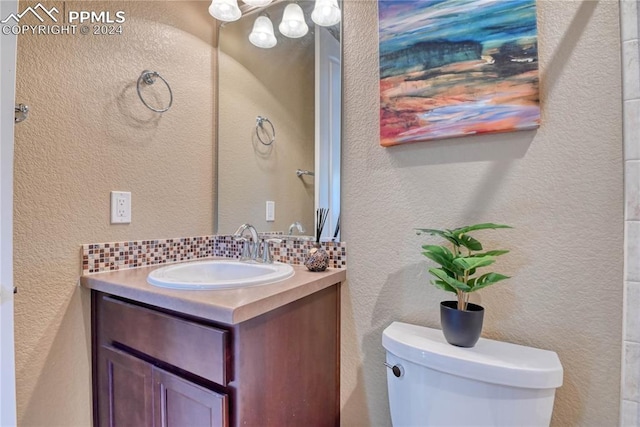 bathroom featuring decorative backsplash, vanity, and toilet