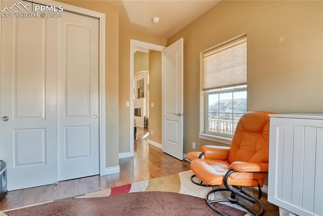 sitting room with radiator heating unit and light wood-type flooring