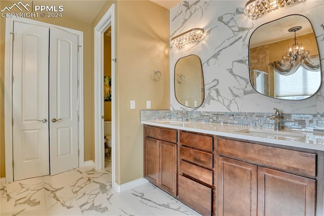 bathroom featuring vanity, toilet, and a chandelier