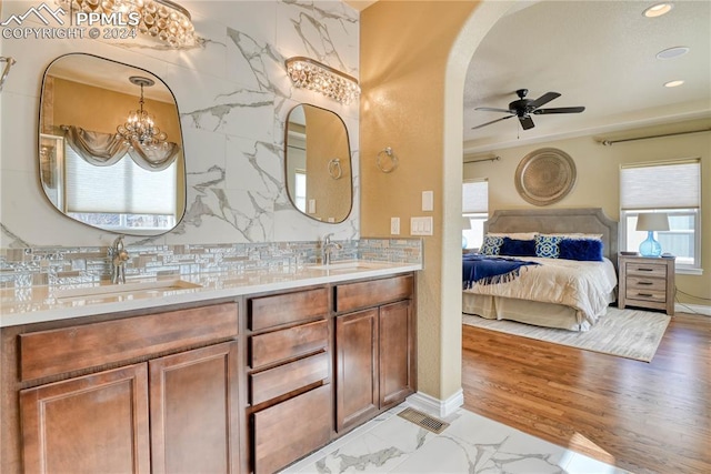 bathroom featuring hardwood / wood-style floors, ceiling fan with notable chandelier, backsplash, and vanity