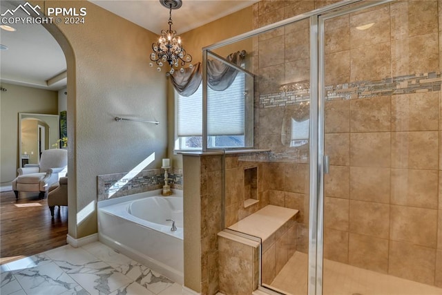 bathroom featuring hardwood / wood-style floors, a notable chandelier, and separate shower and tub