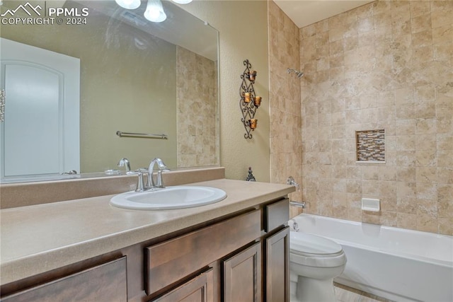 full bathroom featuring toilet, vanity, and tiled shower / bath